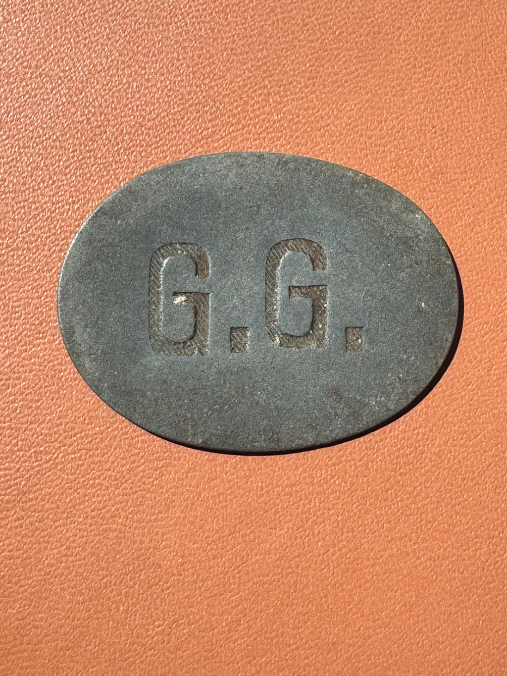 Żeton dominialny G.G. Machcin - awers (inicjały G.G.)